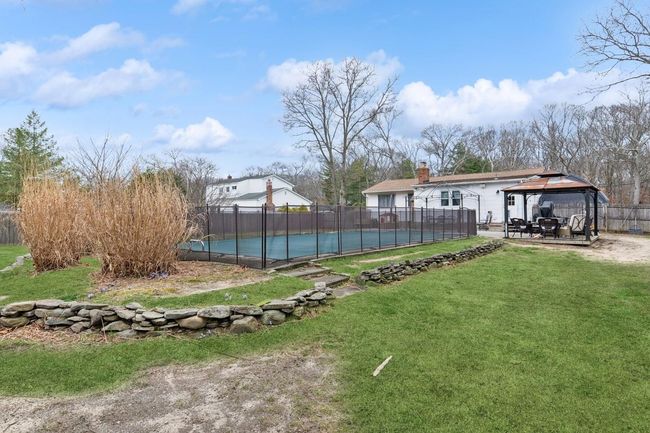 View of yard featuring a fenced in pool, a gazebo, a patio area | Image 32