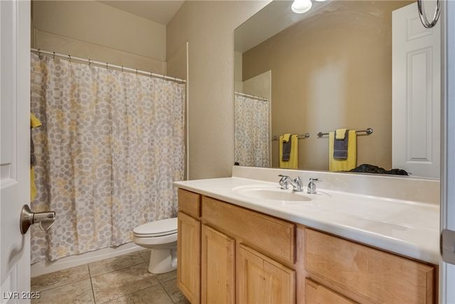 Full bath with a shower with shower curtain, toilet, tile patterned flooring, and vanity | Image 41