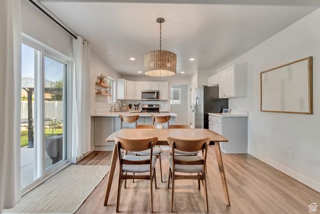 Dining space with light wood-type flooring, recessed lighting, and a chandelier | Image 8