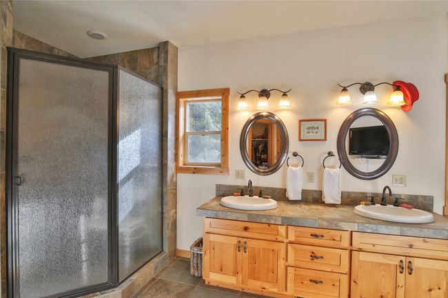 Full bath with a sink, double vanity, a shower stall, and tile patterned flooring | Image 18