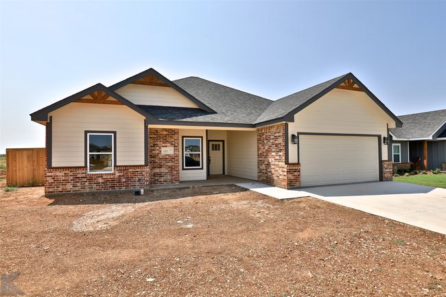 View of front of house with brick siding, an attached garage, concrete driveway, and roof with shingles | Image 34