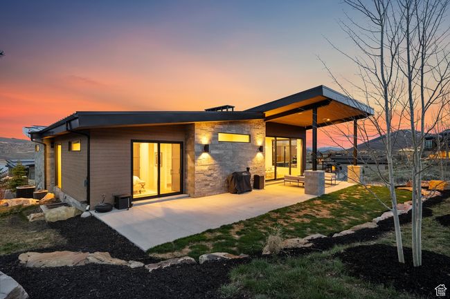 Rear view of property featuring stone siding and a patio area | Image 13