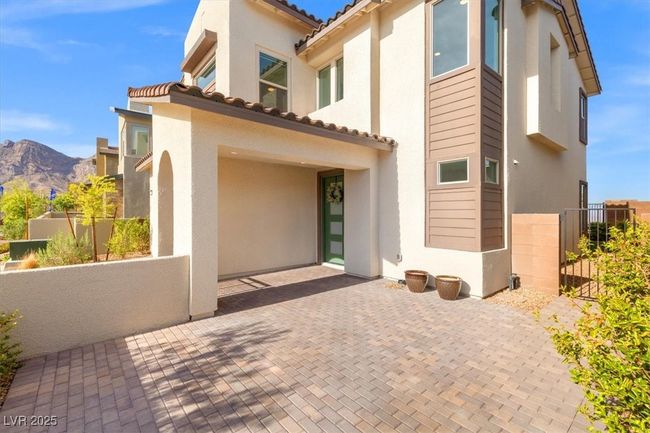 Back of property featuring stucco siding, fence, a tile roof, a patio area, and a mountain view | Image 19
