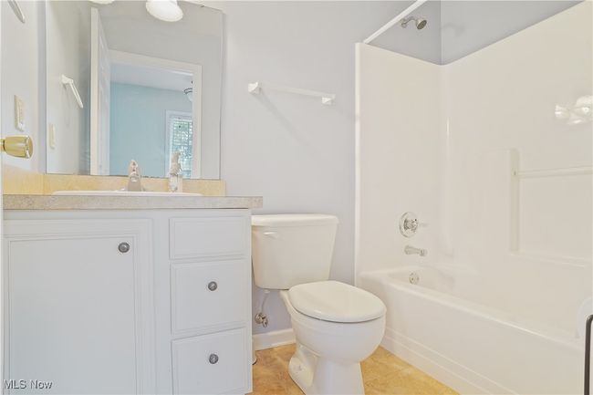 Full bath with toilet, vanity, tub / shower combination, tile patterned floors, and baseboards | Image 8
