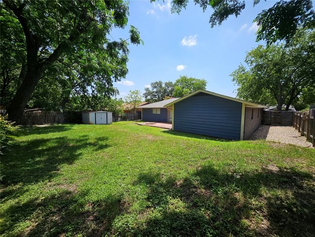 Fenced backyard featuring a storage shed | Image 23