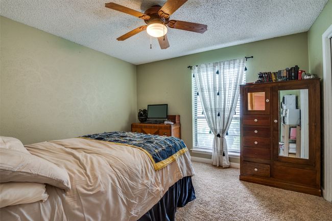 Carpeted bedroom with a textured ceiling and ceiling fan | Image 19