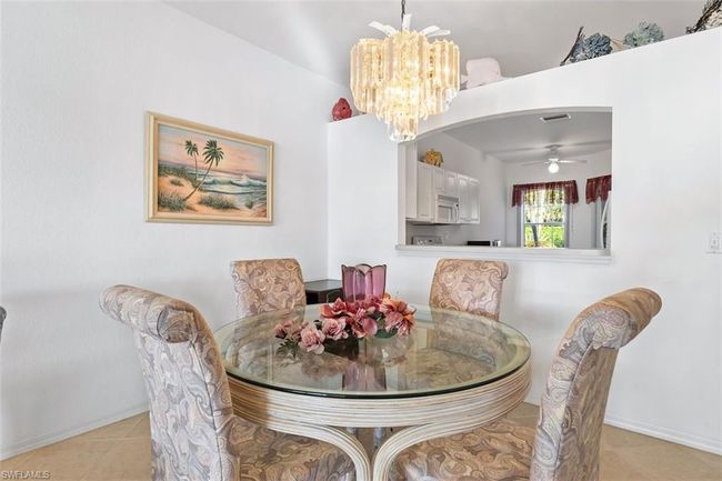 Tiled dining area with ceiling fan with notable chandelier | Image 11