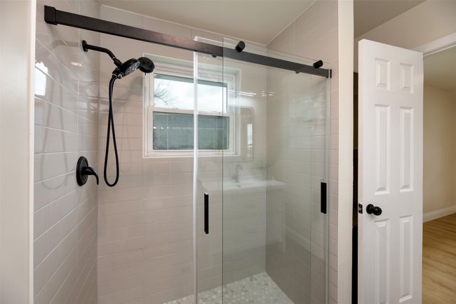 Full bath featuring a shower stall and wood finished floors | Image 15