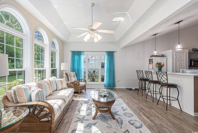 Living room featuring wood finished floors, ceiling fan, vaulted ceiling, and baseboards | Image 16