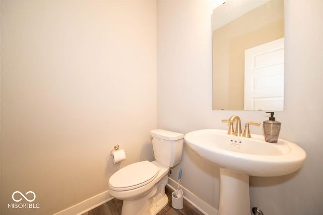 half bathroom featuring baseboards and wood finished floors | Image 12