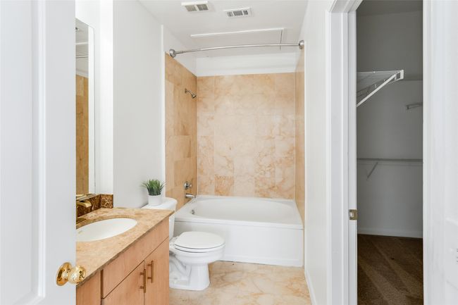 Bathroom with vanity, shower / bathtub combination, and a walk in closet | Image 20