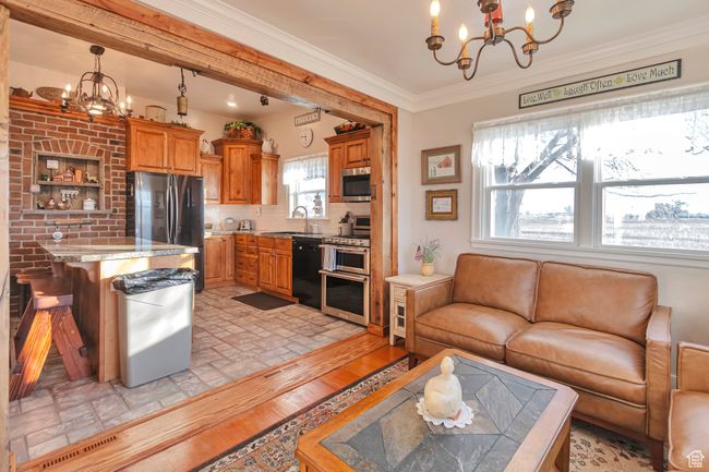 Living room with sink, crown molding, a chandelier, and light hardwood / wood-style floors | Image 37