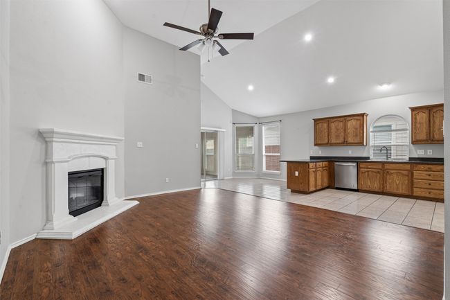 Kitchen with dishwasher, open floor plan, dark countertops, high vaulted ceiling, and a ceiling fan | Image 21