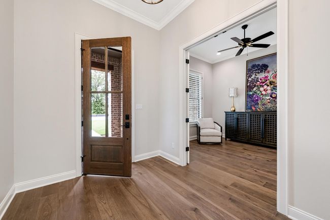 Entrance foyer with wood finished floors, crown molding, and ceiling fan | Image 8
