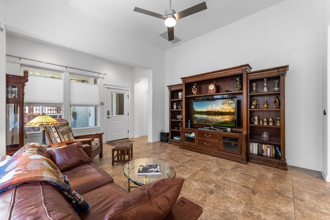 Living room with visible vents, baseboards, a ceiling fan, and arched walkways | Image 14