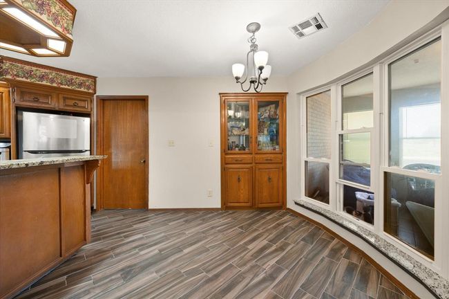 Unfurnished dining area with a chandelier, dark wood-style floors, and baseboards | Image 15