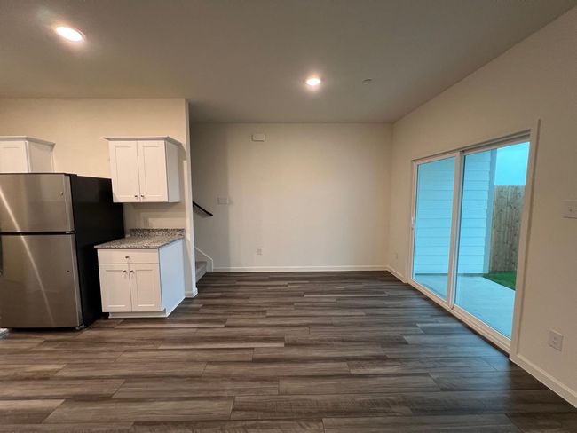 Kitchen with freestanding refrigerator, white cabinets, dark wood-style floors, recessed lighting, and baseboards | Image 7