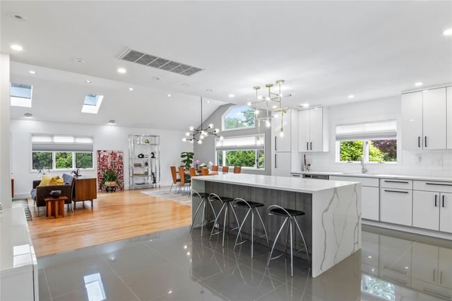 Kitchen with light tile patterned flooring, plenty of natural light, a kitchen island, a breakfast bar, and recessed lighting | Image 8