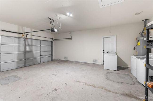 Garage with washer and dryer, water heater, and a garage door opener | Image 5