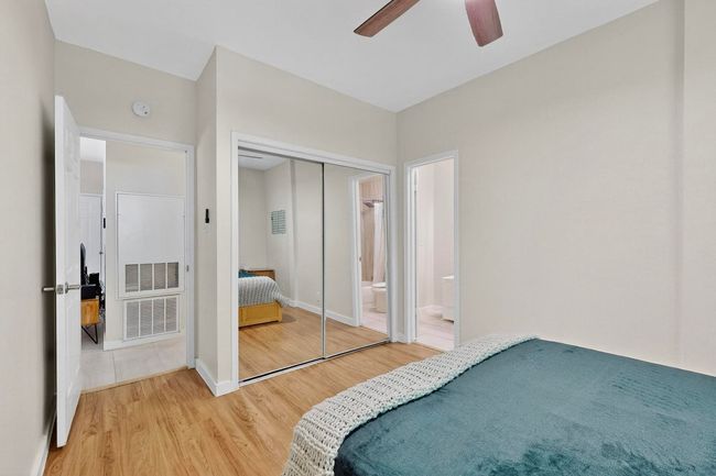 Bedroom featuring light wood-type flooring, a closet, ceiling fan, and ensuite bath | Image 21