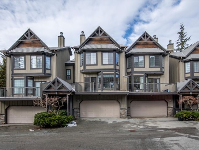 Townhome / multi-family property with stone siding, driveway, a chimney, and an attached garage | Image 33