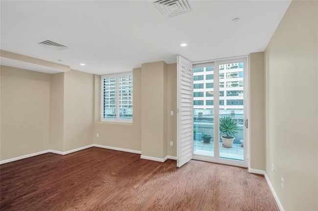 The sliding doors to terrace with plantation shutters open. All windows in home overlook the terrace with skyline in background. | Image 19