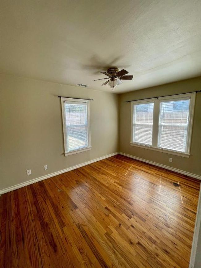 Empty room featuring a ceiling fan, baseboards, and wood finished floors | Image 9