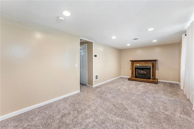Unfurnished living room featuring recessed lighting, carpet floors, a fireplace with raised hearth, baseboards, and visible vents | Image 31