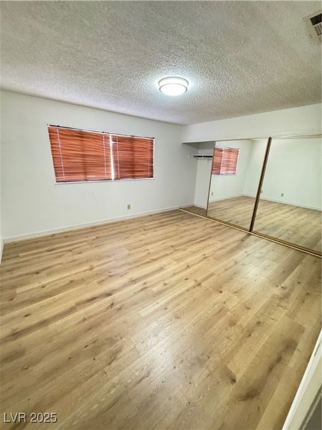 Unfurnished bedroom featuring hardwood / wood-style floors, a textured ceiling, and a closet | Image 29
