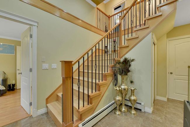 Staircase featuring ornamental molding, baseboards, and a baseboard heating unit | Image 17