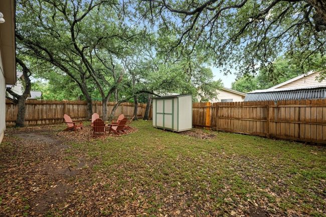 Fenced backyard with a storage shed and a fire pit | Image 29