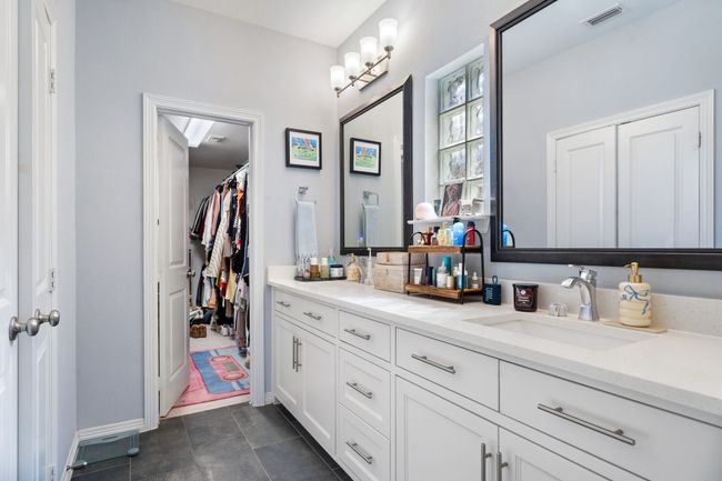 Full bathroom with double vanity, tile patterned flooring, and a walk in closet | Image 16