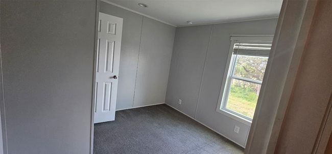 Carpeted empty room featuring ornamental molding and healthy amount of natural light | Image 4