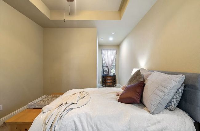 Bedroom with a ceiling fan, a tray ceiling, and baseboards | Image 27