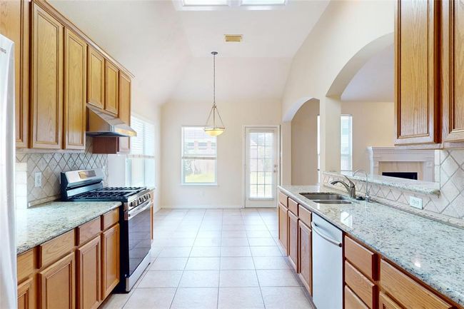 Kitchen is upgraded with granite countertops and beautifully tiled backsplash | Image 16