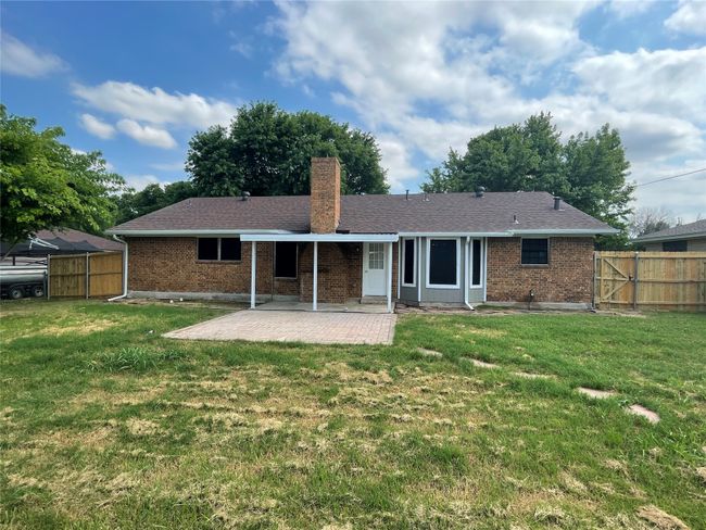 Back of property featuring a patio area, a chimney, brick siding, and a gate | Image 16