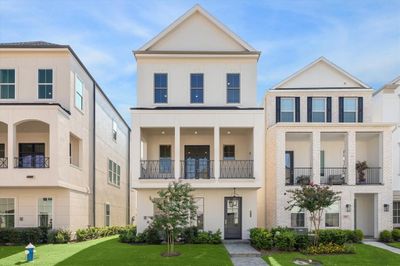 Inside the Guard Gated Houston Community inside the Loop is a 3 story Pelican Builder Built home with an Elevator shaft and outdoor living with green grass in the front of the home. | Image 1