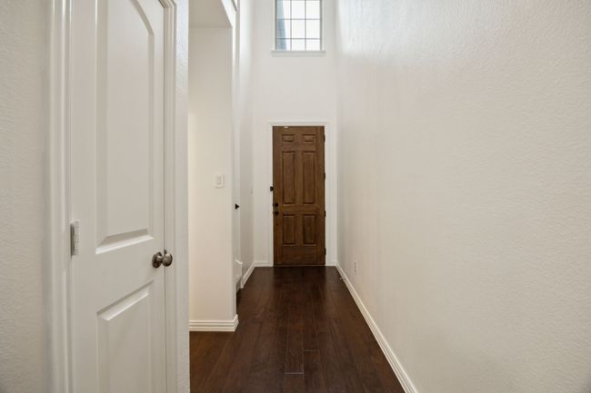 Hall featuring dark wood finished floors and baseboards | Image 10