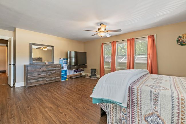 Bedroom with wood finished floors, baseboards, and a ceiling fan | Image 11