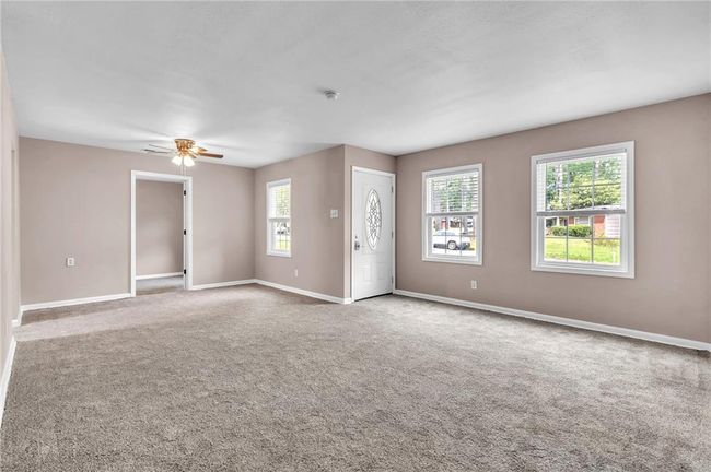 Carpeted empty room with baseboards and ceiling fan | Image 10