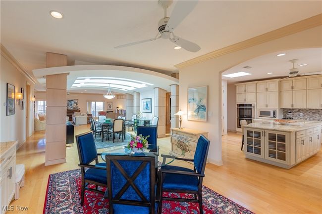 Dining area off kitchen with sliders to balcony. with light wood floors, recessed lighting, ceiling fan, crown molding. and built-ins | Image 8