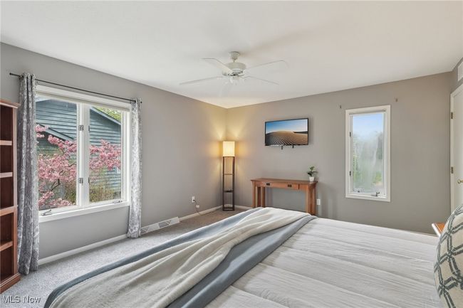 Carpeted bedroom featuring baseboards, visible vents, and a ceiling fan | Image 31