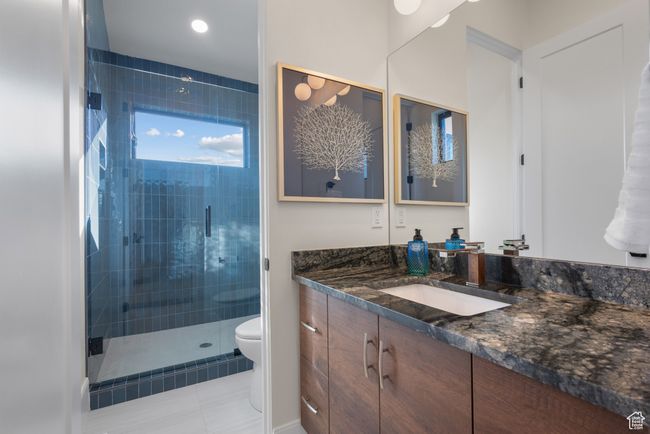 Bathroom featuring vanity, a stall shower, tile patterned floors, and recessed lighting | Image 51