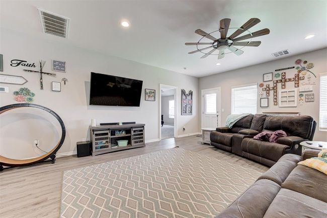 Living room with ceiling fan, light wood-style flooring, and recessed lighting | Image 9