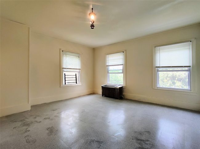 Unfurnished room with radiator, a textured wall, and a paneled ceiling | Image 18
