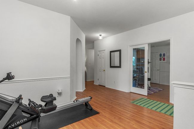 Exercise room featuring wood finished floors and arched walkways | Image 8