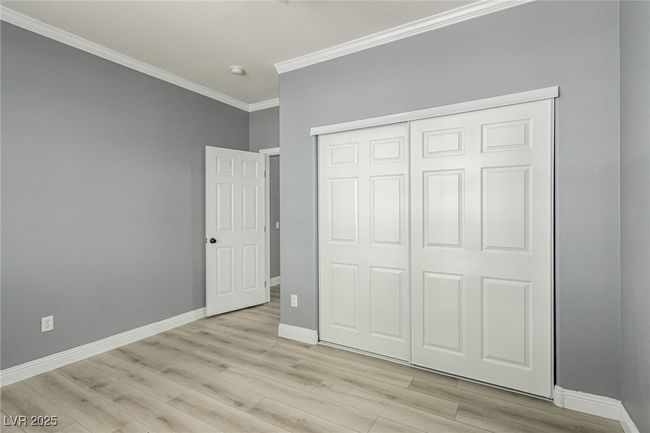 Guest bedroom featuring crown molding, a closet and light wood-type flooring | Image 24