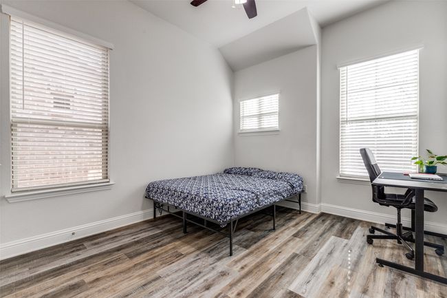 Bedroom featuring baseboards, wood finished floors, a ceiling fan, and vaulted ceiling | Image 15