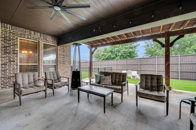 Fenced backyard with outdoor lounge area, ceiling fan, and a patio | Image 29