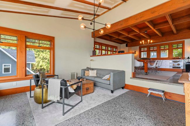 Living area with a chandelier, speckle patterned floor, radiator, wooden ceiling with exposed beams, and baseboards | Image 14